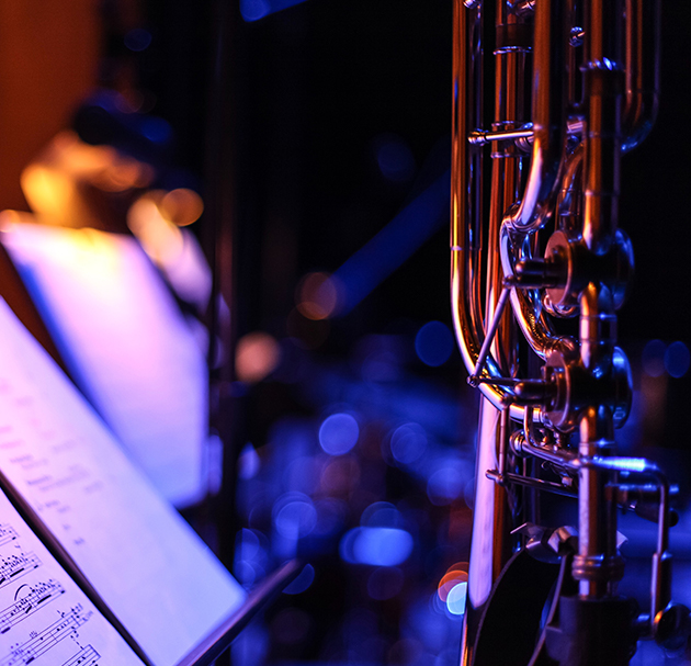 Depth of field shot of a bassoon with a dark blurry orchestral background