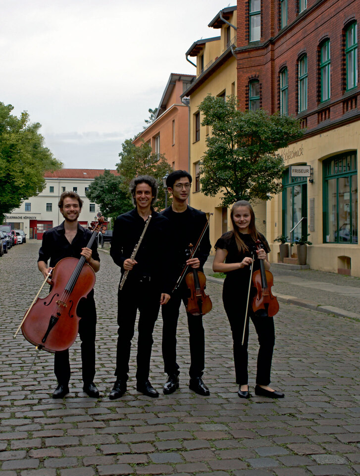 Group shot of four instrumentalists on a German street